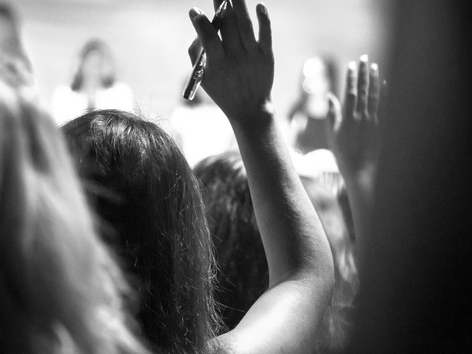 Hands raised in an audience during a presentation.